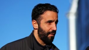 Ruben Amorim, le visage sérieux se détachant sur un ciel bleu dégagé et vêtu d'une veste sombre, revient sur son récent départ de Manchester United.