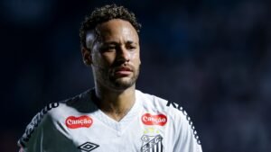 Neymar in het witte tenue van Santos toont een serieuze uitdrukking na een wedstrijd, terwijl hij nadenkt over zijn terugkeer na de operatie te midden van de clubkleuren.