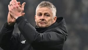 Ole Gunnar Solskjær salue les supporters, vêtu d'une veste noire et les cheveux grisonnants, exprimant sa gratitude après un match.