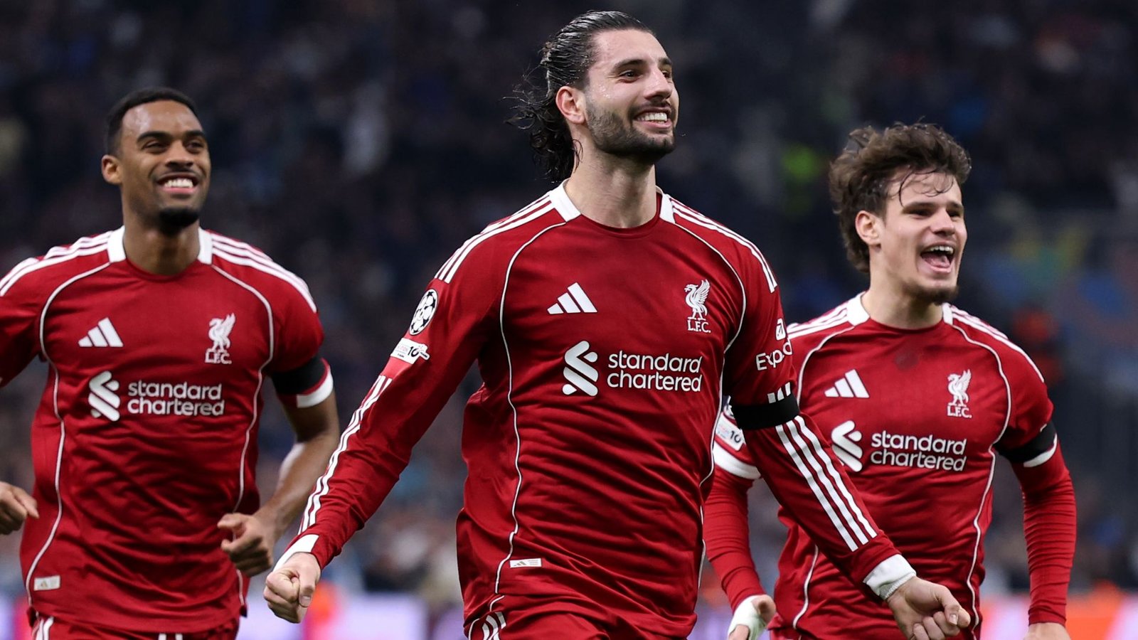 Les joueurs de Liverpool célèbrent un but dans leur emblématique maillot rouge, illustrant la joie et l'esprit d'équipe lors d'un match de Ligue des champions de l'UEFA.