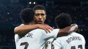 Bellingham célèbre avec Vinícius Jr. et Rodrygo après un match, illustrant leur unité et leur esprit d'équipe dans le maillot blanc du Real Madrid.