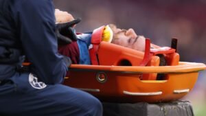 West Ham-verdediger Mavropanos op een brancard, die medische hulp krijgt na een hoofdletsel tijdens een wedstrijd.