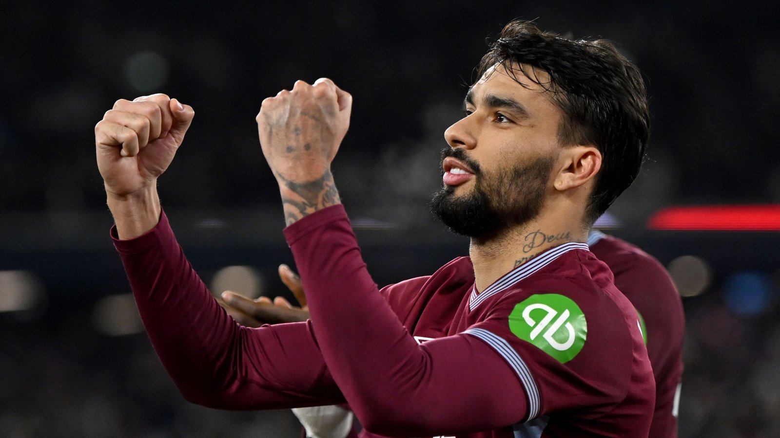 Lucas Paquetá viert een doelpunt in het bordeauxrood en blauw tenue van West Ham, toont enthousiasme met geheven vuisten in een stadionsetting.