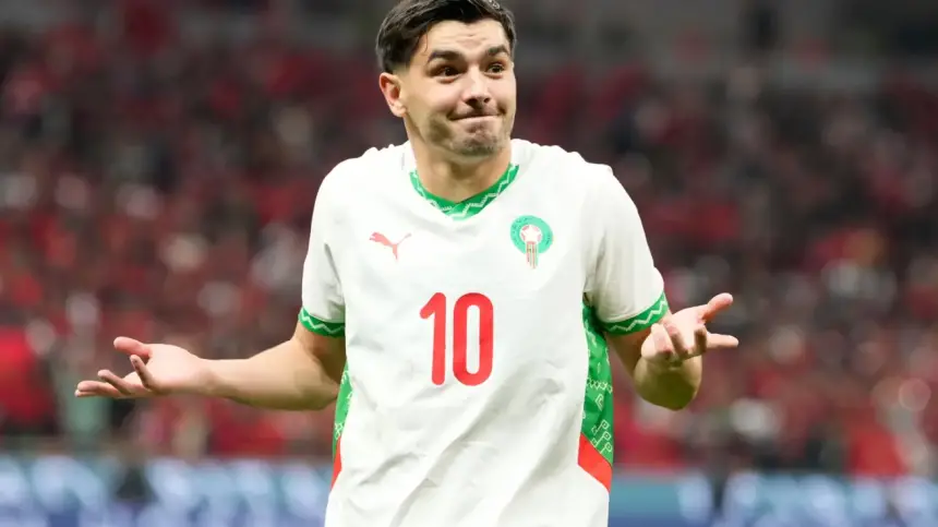 Brahim Diaz dans le maillot national du Maroc, gesticulant avec une expression perplexe pendant un match, célébrant la performance de son équipe.