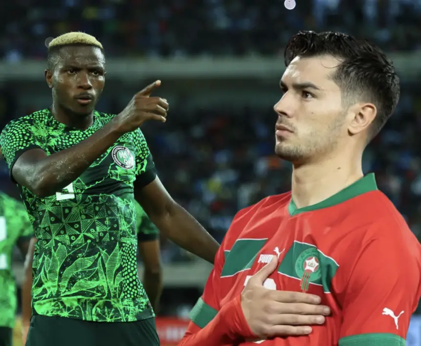 Un joueur nigérian en maillot vert gesticule avec assurance, tandis qu'un joueur marocain en tenue rouge a la main sur le cœur, illustrant un moment tendu du match.