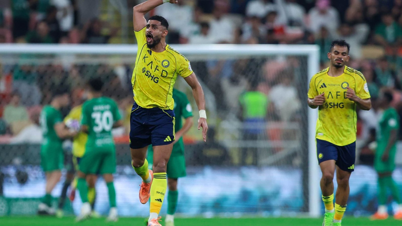 Al Nassr players in yellow kits celebrate a decisive moment during a match, with green-clad opponents in the background.