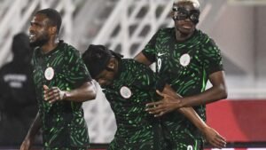 Des joueurs de football marocains célébrant lors d'un match avec des maillots de l'équipe nationale.