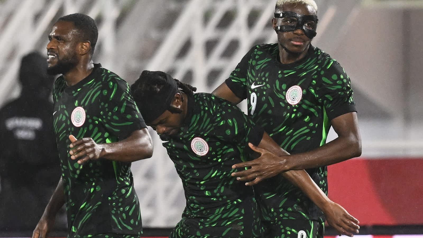 Des joueurs de football marocains célébrant lors d'un match avec des maillots de l'équipe nationale.