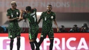 Les joueurs nigérians célèbrent pendant la Coupe d'Afrique des Nations 2023, portant des tenues vert vif sur fond de stade.