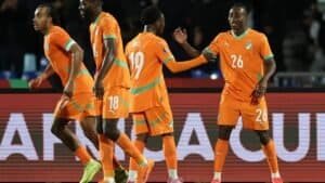 Ivorian players celebrate in their vibrant orange kits during the Africa Cup, showcasing camaraderie and excitement on the pitch.