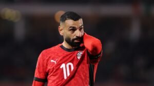 Mohamed Salah porte le maillot rouge de l'Égypte, numéro 10, avec une expression concentrée, lors d'un moment tendu dans un cadre de match.