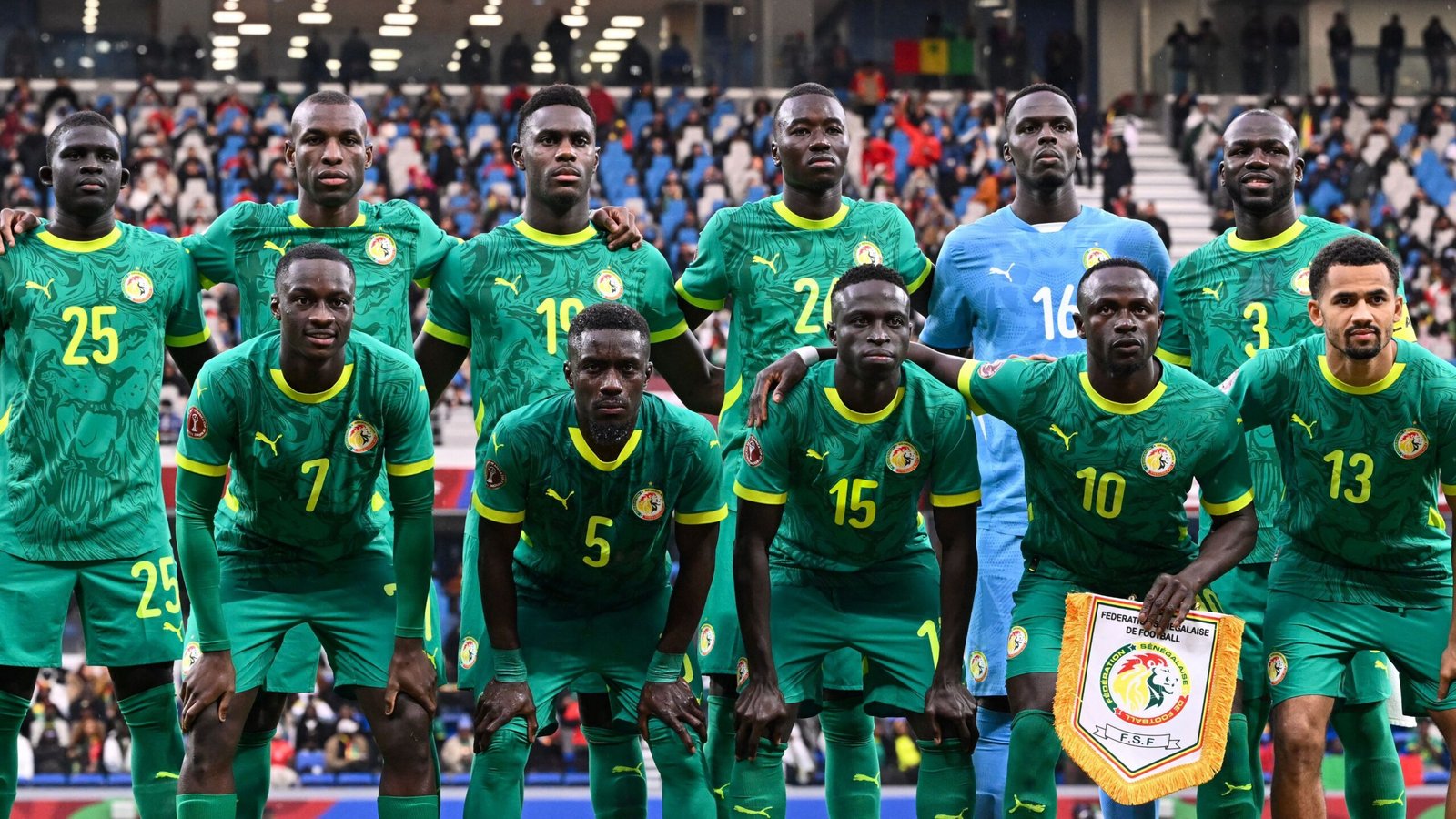 Senegal's national football team poses for a team photo in vibrant green kits featuring the federation badge, during an international match.