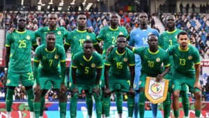 Senegal's national football team poses for a photo in their green kits with yellow details, displaying team spirit before a match.
