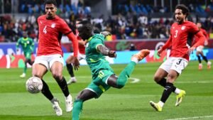 Senegal's player in green, number 10, makes a striking attempt on goal against the Egyptian defence in a tense AFCON match.