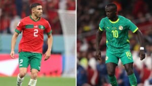 Achraf Hakimi in Morocco's red kit and Sadio Mané in Senegal's vibrant green kit face off during a competitive match.