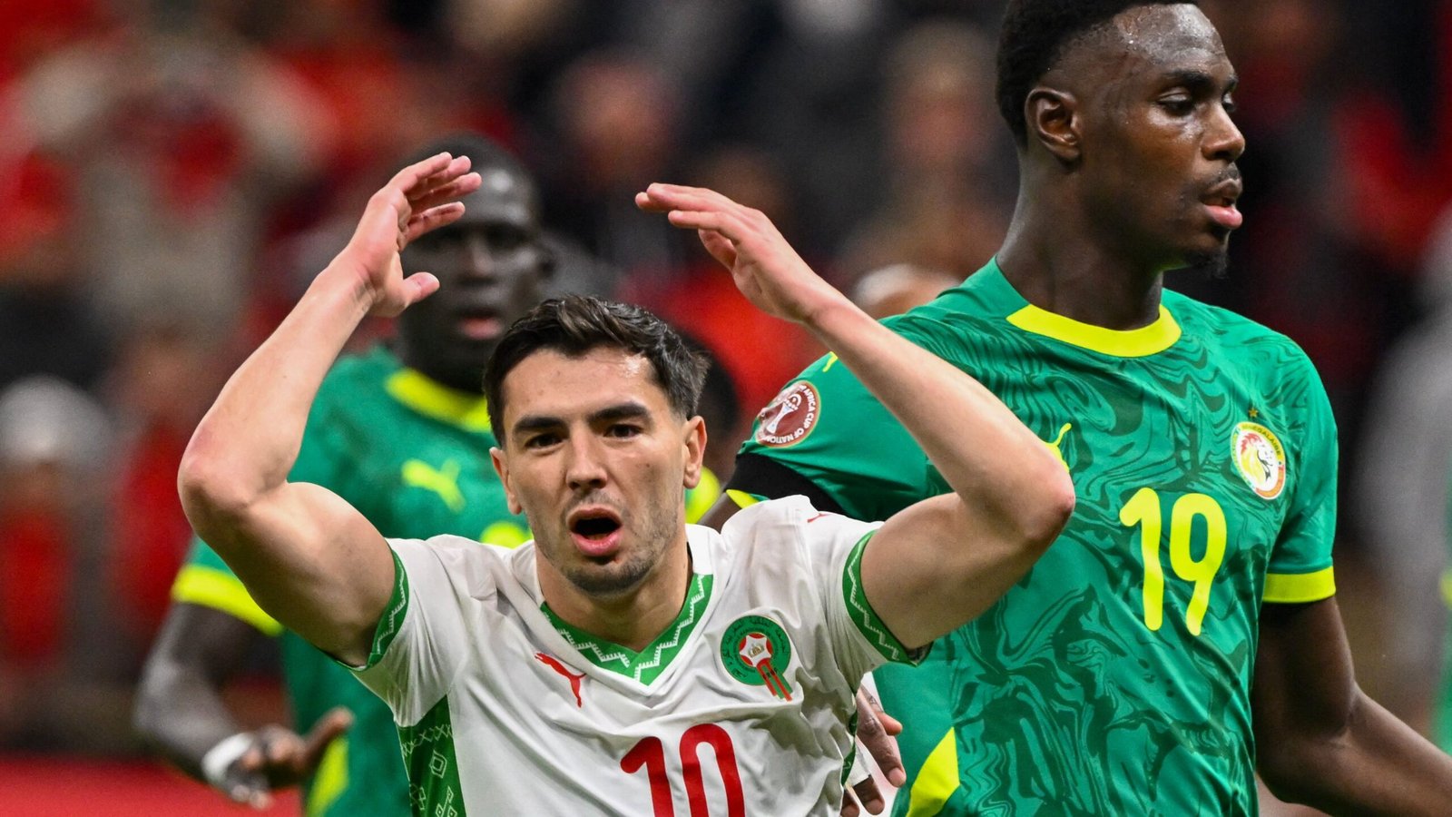 Moroccan player wearing jersey number 10 expresses frustration during a match against Senegal, showcasing intense competition and emotion.