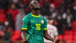 Sadio Mané célèbre avec fougue dans le maillot vert du Sénégal, sous la pluie et les acclamations de la foule.