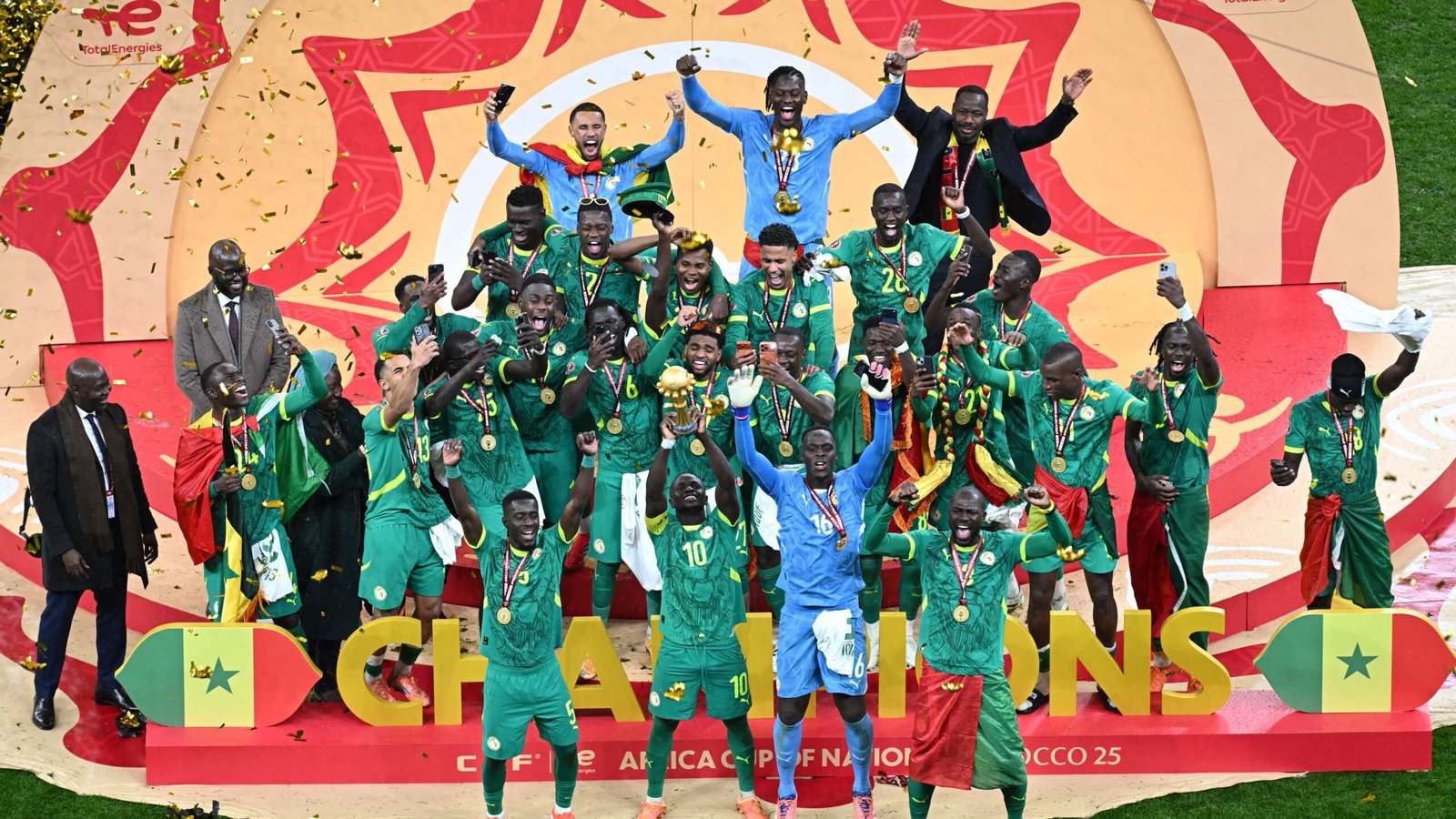 Senegal's national team celebrates their Africa Cup of Nations victory, adorned in green kits, holding the trophy and medals amidst confetti.