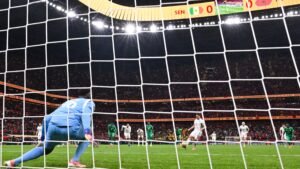 L'attaquant marocain tire un penalty lors du match de la Coupe d'Afrique des Nations contre le Sénégal, tandis que le gardien se prépare à l'arrêter.