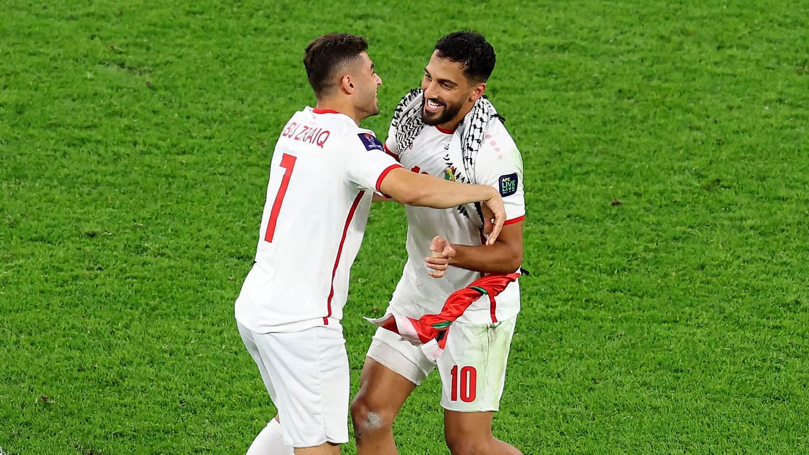 احتفاءً، يتعانق اللاعبون مرتدين القمصان البيضاء بفرح على أرض الملعب، مما يبرز روح كرة القدم المغربية والعمل الجماعي.