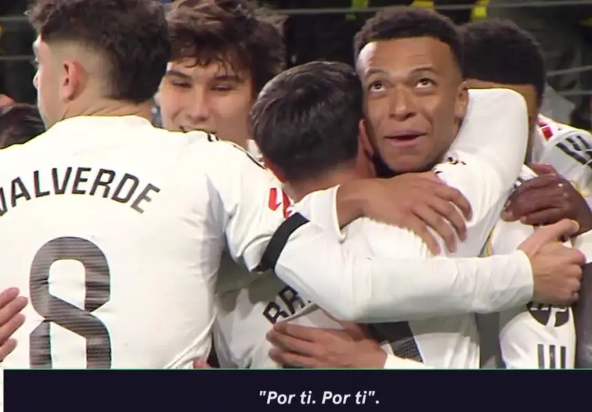 Mbappé celebrating with teammates in white kits, including Valverde, after a goal, with a caption "Por ti. Por ti". Football joy encapsulated.
