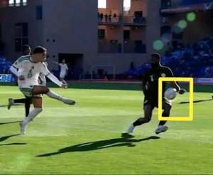 Un joueur marocain en maillot blanc numéro 17 tente un tir tandis qu'un joueur nigérian en maillot noir numéro 6 se prépare à remettre le ballon dans un stade.