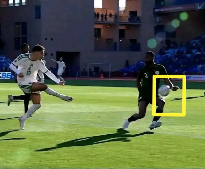 Un joueur marocain en maillot blanc numéro 17 tente un tir tandis qu'un joueur nigérian en maillot noir numéro 6 se prépare à remettre le ballon dans un stade.