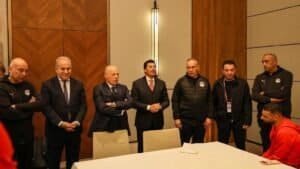 Een groep Egyptische voetbalfunctionarissen in vergadering, besprekend strategie, gekleed in teamtenue, met focus op samenwerking.