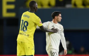 Brahim Díaz in Real Madrid-tenue en Pape Gueye in geel Villarreal-shirt tijdens een wedstrijd, waarbij competitieve interactie zichtbaar is.