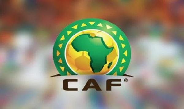 Logo de la CAF présentant un cercle vert avec une silhouette du continent africain et un ballon de football, entouré de motifs jaunes et verts.