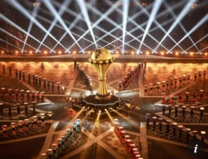 AFCON trophy surrounded by performers in vibrant costumes, illuminated by stage lights, creating a festive atmosphere for the tournament.