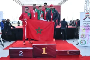 Marokkaanse atleten tonen trots de nationale vlag op het podium na het behalen van de eerste plaats, met medailles en trofeeën in een feestelijke sfeer.