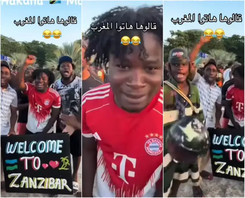Group of fans celebrating in Zanzibar, wearing football jerseys, holding a sign saying "Welcome to Zanzibar" with palm trees in the background.