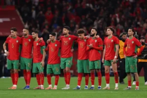 L'équipe nationale du Maroc alignée, vêtue de tenues rouges et vertes, affiche résilience et unité après un match.