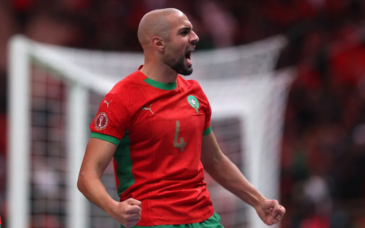 Moroccan player celebrating passionately in a vibrant red kit with green accents during the Africa Cup quarter-finals, 2025.