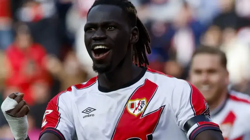 لاعب رايو فايكانو يحتفل برفع قبضته، مرتدياً زي أبيض وأحمر، معبراً عن حماسه خلال مباراة.