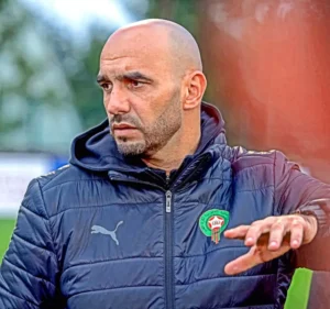 Walid Regragui, Moroccan national football team coach, in a black Puma jacket, gesturing during training session.