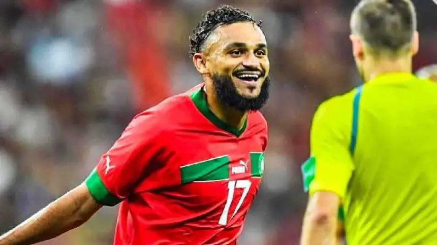 Soufian Boufal célèbre avec joie dans le maillot rouge à accents verts du Maroc, affichant son numéro de joueur 17 lors d'un match intense.