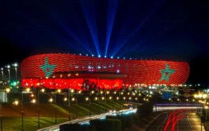 Stadion verlicht in rood en groen met een prominent stersymbool, dat 's nachts de voetbaltrots van Marokko toont.