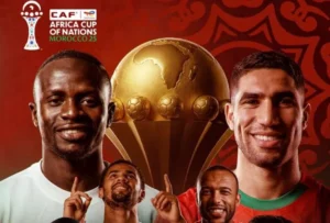 Celebration of the Africa Cup of Nations with Moroccan players, including Achraf Hakimi; a golden trophy and vibrant red background.