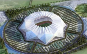 Futuristic stadium design surrounded by greenery, featuring a distinctive pointed roof, set for the 2030 World Cup final between Morocco and Spain.