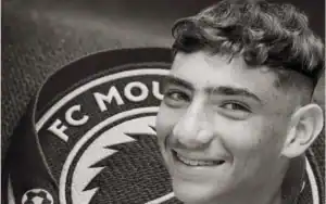 Yousri Khachroub souriant à côté du logo du FC Mouloudia Marrakech, sur fond noir texturé.