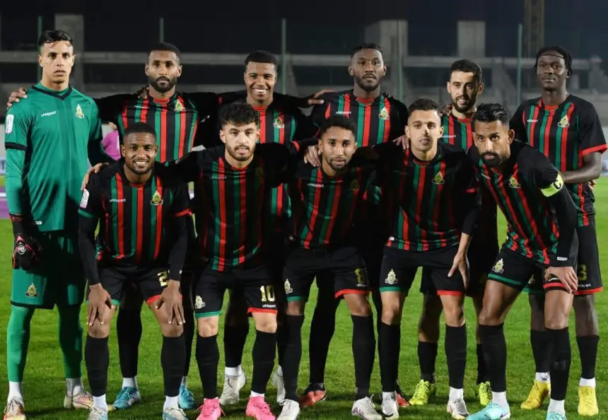 Royal Armed Forces FC teamopstelling, met spelers in rood-groen gestreepte tenues, poserend samen op het veld voor een wedstrijd.