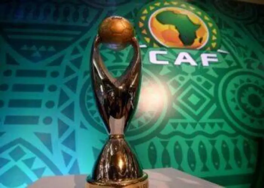De CAF Champions League-trofee wordt getoond op een levendige groene achtergrond met Afrikaanse patronen en het CAF-embleem.