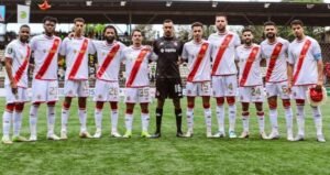 Wydad Casablanca players line up for a team photo, showcasing their red and white kits, with goalkeeping attire in black.
