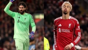 Liverpool's Alisson Becker gestures during a match, while Hugo Ekitike looks disappointed, both in the team's red kit.