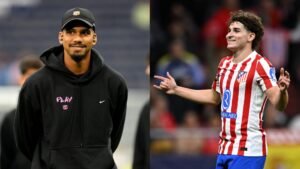 Araujo in een zwarte hoodie lacht naast Atlético's spits Julián Álvarez in een rood-wit gestreept shirt, beiden aan het vieren van voetbal.