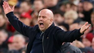 Arne Slot spoort Liverpool gepassioneerd aan tot aanvallen tijdens een wedstrijd, terwijl hij nadrukkelijk gebaren maakt voor een betrokken publiek.