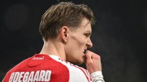 Martin Ødegaard, wearing an Arsenal jersey, looks pensive while biting his fingernails during the match against Chelsea.