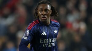 Eberechi Eze in het marineblauw en rode tenue van Arsenal, alert en gefocust op het veld tijdens een Premier League-wedstrijd.